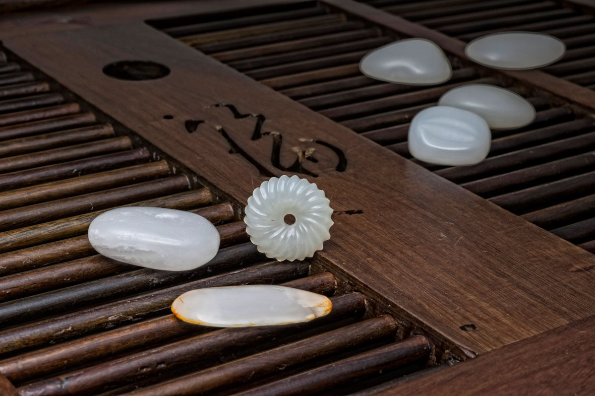 Seven pieces of what appears to be Chinese nephrite purchased in Guangzhou's Hualin Street jade market on 2 April 2012 by three of the authors (RWH, WM, ACM). The three pieces in the foreground proved to be genuine nephrite (most likely from Xinjiang), while the four in the background were clever imitations. Lotus Gemology on jade and jade testing.