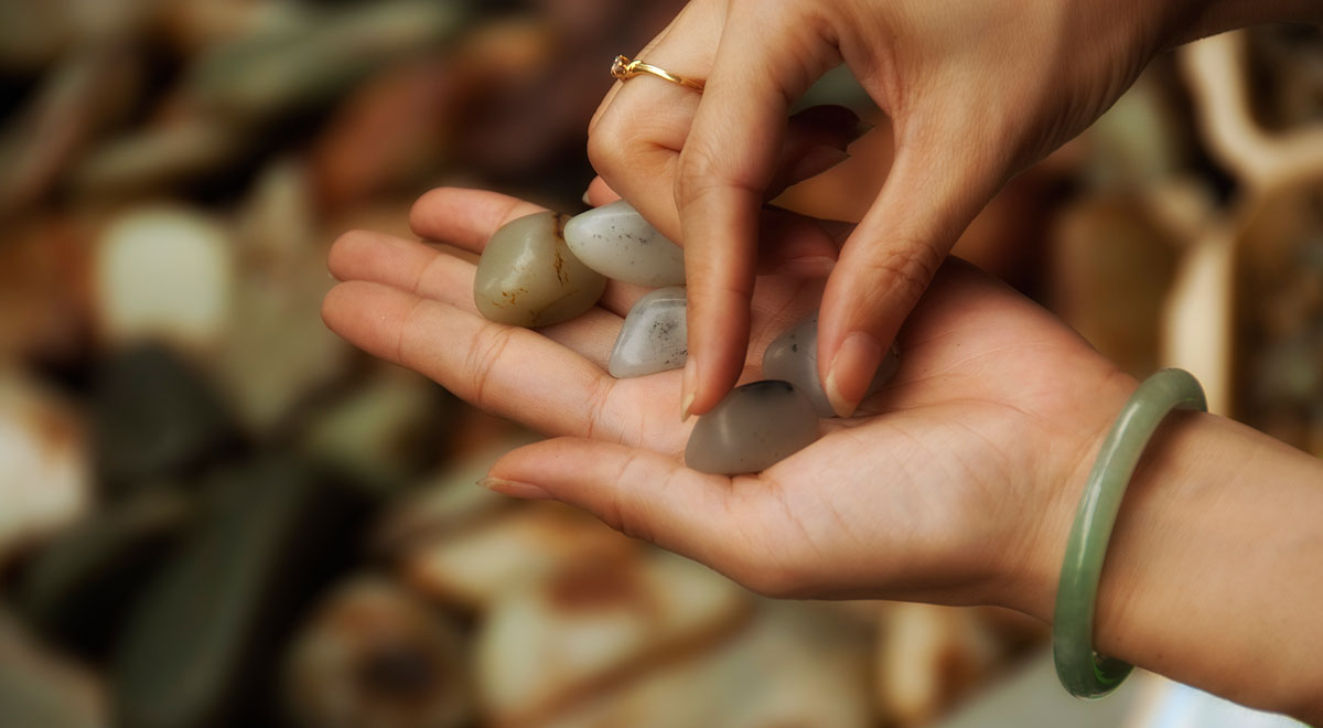 Jade pebbles being examined by a prospective buyer in Guangzhou's Hualin Street jade market. Photo from Lotus Gemology.