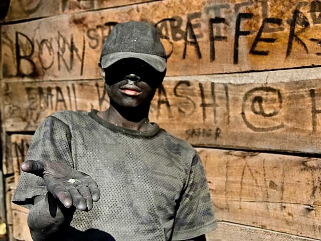 A graphite-coated tanzanite miner at Merelani's Block D holds a small piece of calcite.