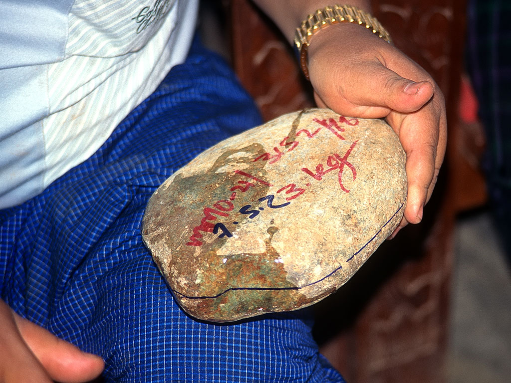 Figure 10. Water readily reveals the "show points" of bright green jadeite on this boulder. Photo © Richard W. Hughes.