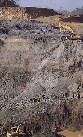 Figure 11. At Nansibon, backhoes are used to work the serpentinite boulder conglomerate in which jadeite boulders occur in narrow horizontal concentrations. Photo © George E. Harlow.