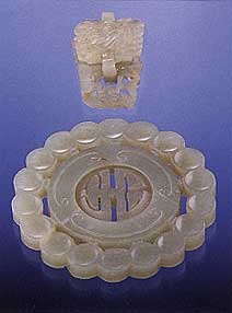 Figure B-1. Nephrite jade, which lies in the actinolite-tremolite series, is an aggregate of densely packed amphibole fibers. It usually has a distinctive greasy surface luster, as shown by these Chinese nephrite carvings. The larger carving measures 5.7 cm in diameter; photo by Maha Tannous.