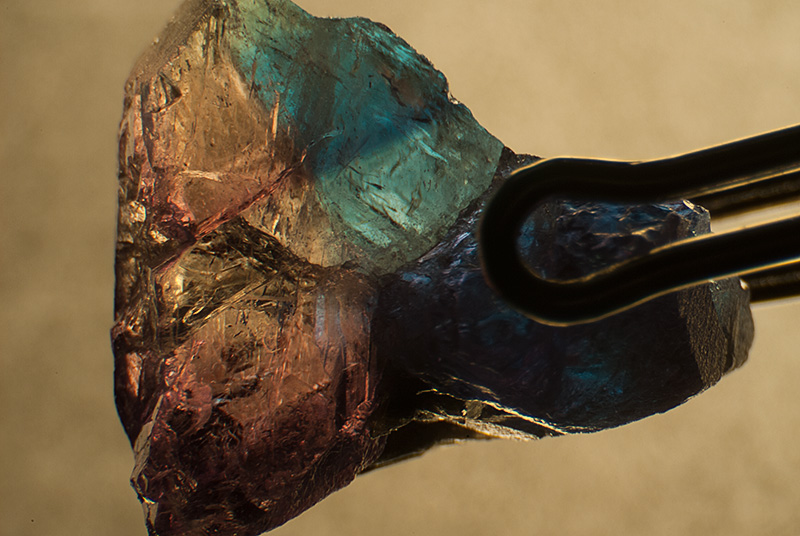 Pleochroism across a twin plane in a Russian alexandrite from Malysheva, Russia when viewed through a polarizing filter. Roll over the image to see the appearance with the polarizer rotated 90°. Specimen courtesy of Tsar Emeralds Corp.; photomicrographs © John I. Koivula/microWorld of Gems