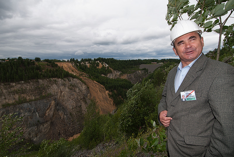 Top:&nbsp;The small village of Malysheva, perches on the very edge of the large open trench (just beyond the trees in the background). Photo: Warren Boyd Bottom: Evgeny Nikolayevich Kazeyev, then of Zelen Kamen (ZK), standing above the large open trench at Malysheva. This pit was created and mined from 1956–1971. Photo: Richard W. Hughes